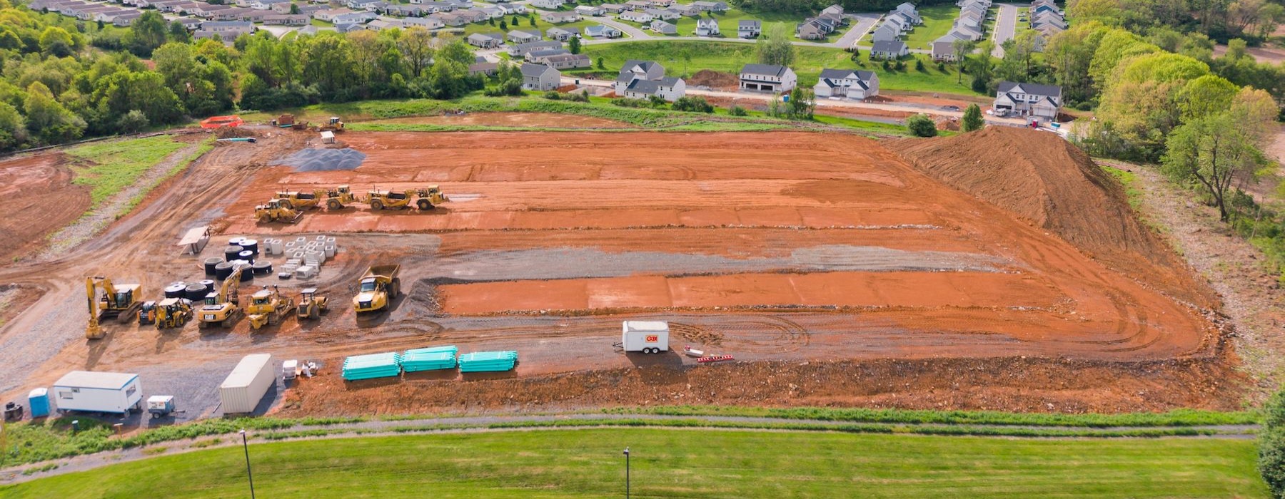 a construction site with a lot of dirt and trees