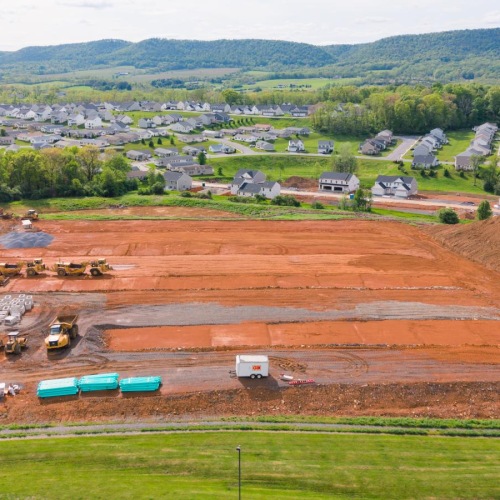 a construction site with a lot of dirt and trees