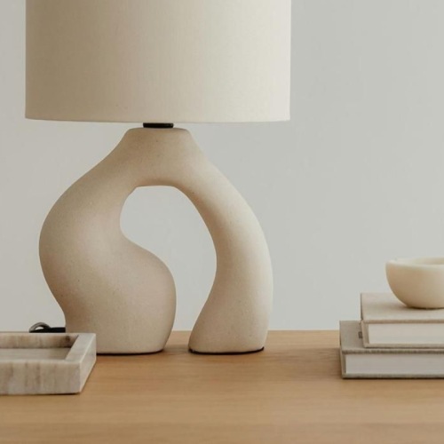 a lamp, stack of books, and decor