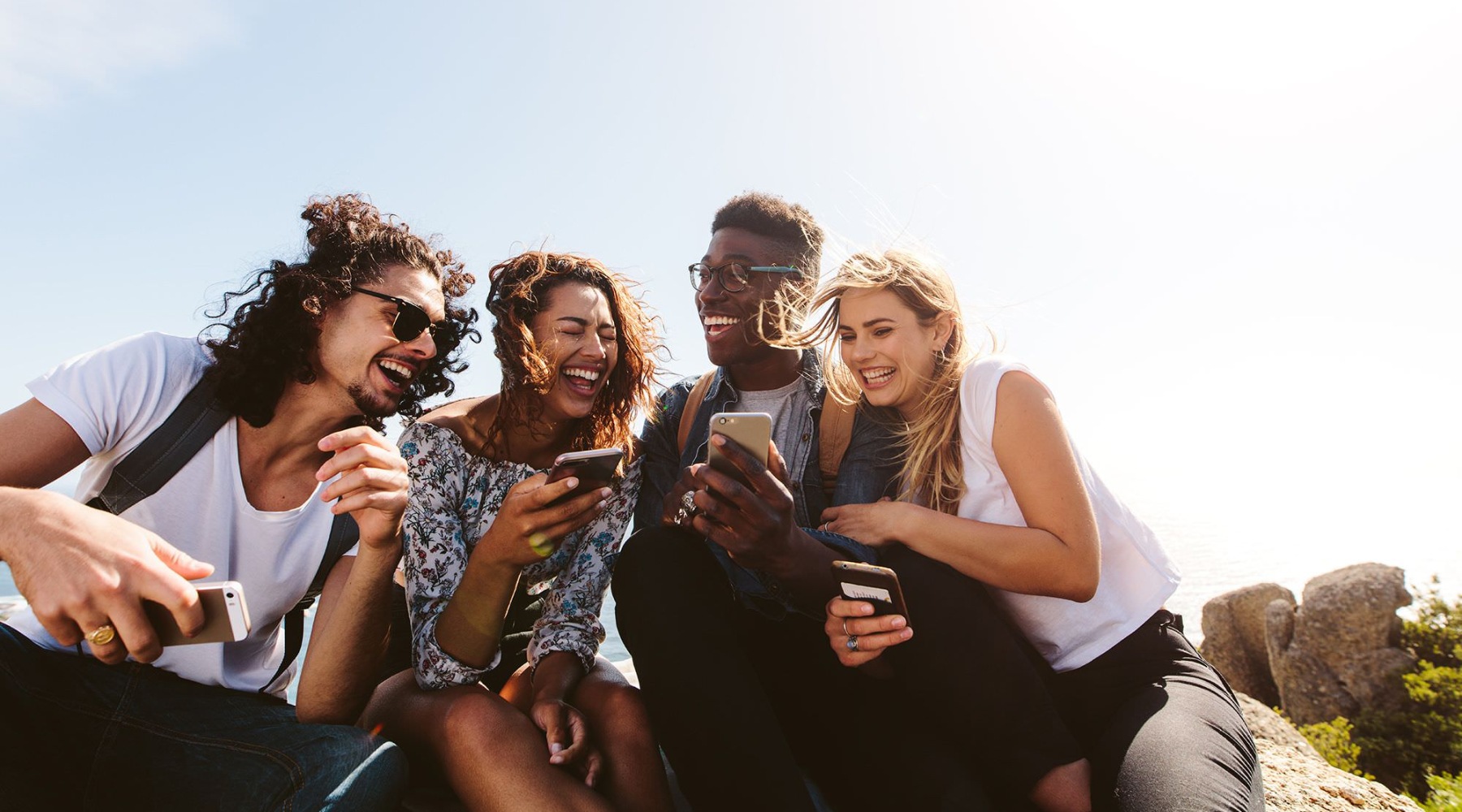 a group of people laughing at a phone